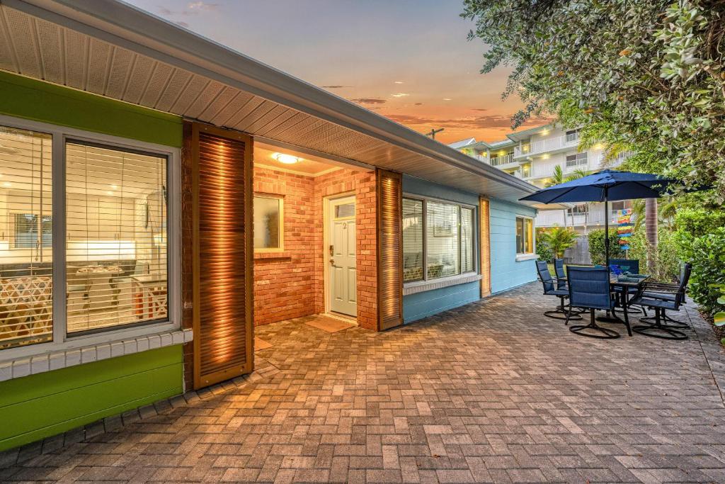 a patio with a table and chairs and an umbrella at Sea Turtle Bungalow - 1136-2 in Siesta Key
