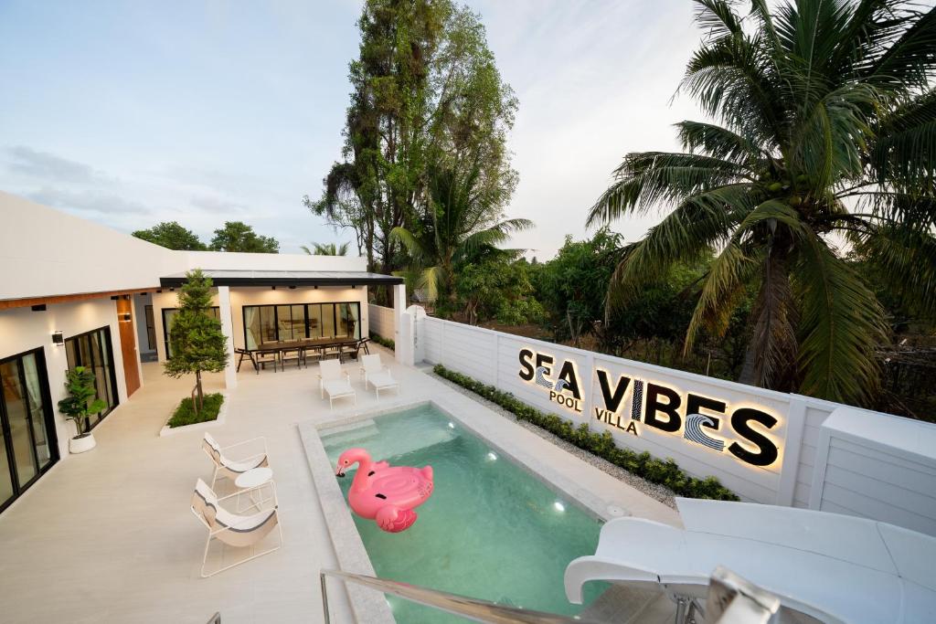 a house with a swimming pool with a pink pig in it at Sea Vibes Pool Villa in Ban Bo So