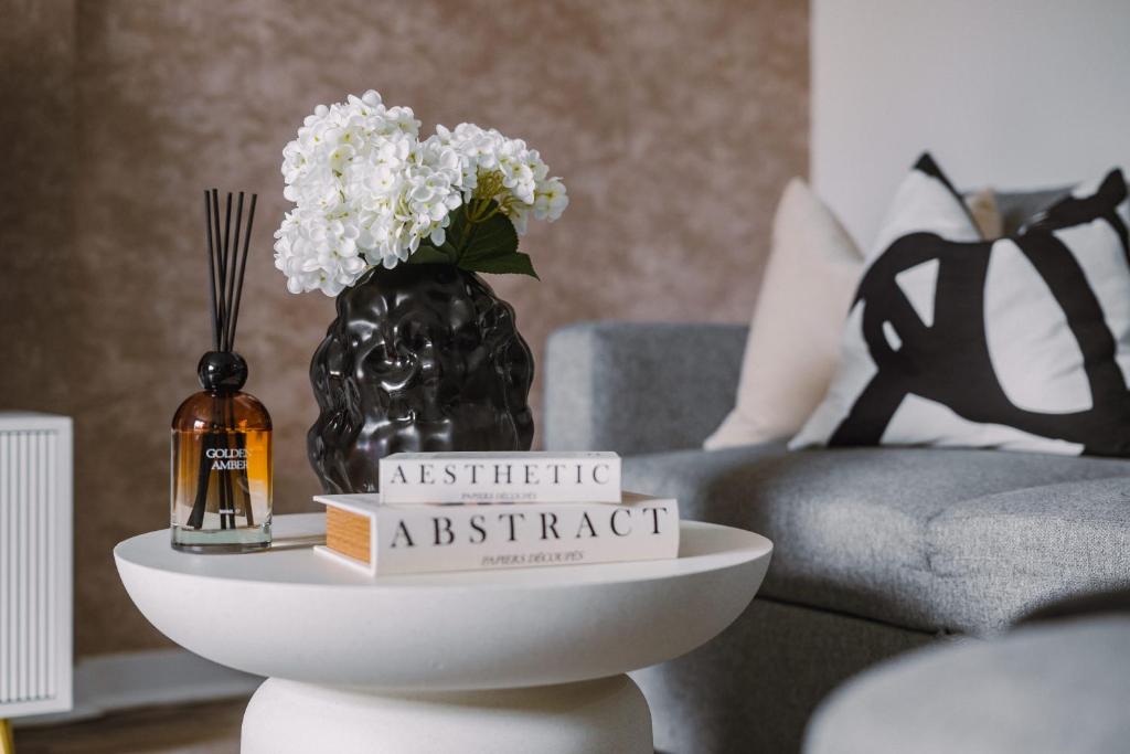 a white table with a vase with flowers on it at SmartSleep Apartments in Glasgow