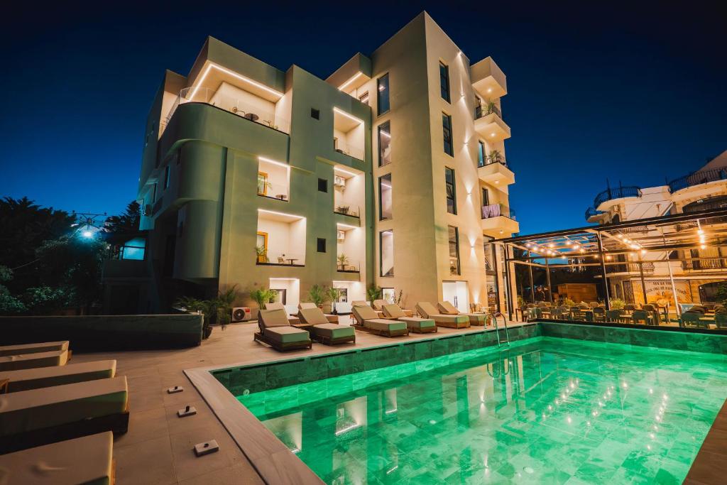 a hotel with a swimming pool in front of a building at Hotel ENAD in Ksamil
