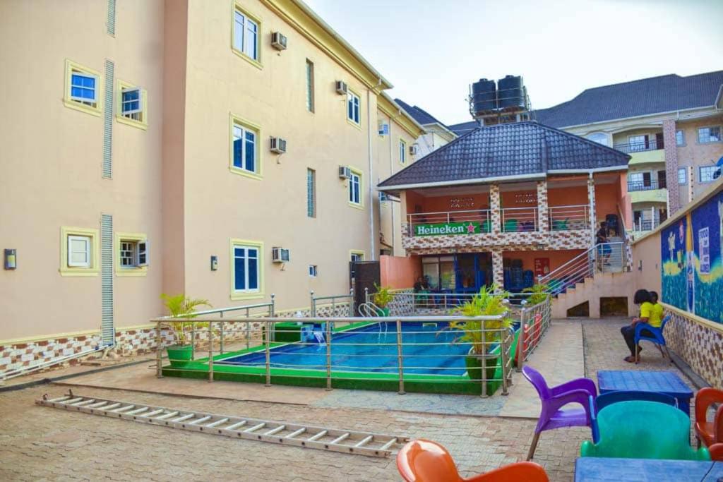 a large building with a swimming pool in a courtyard at Daikon Garden Hotel in Ekwulobia