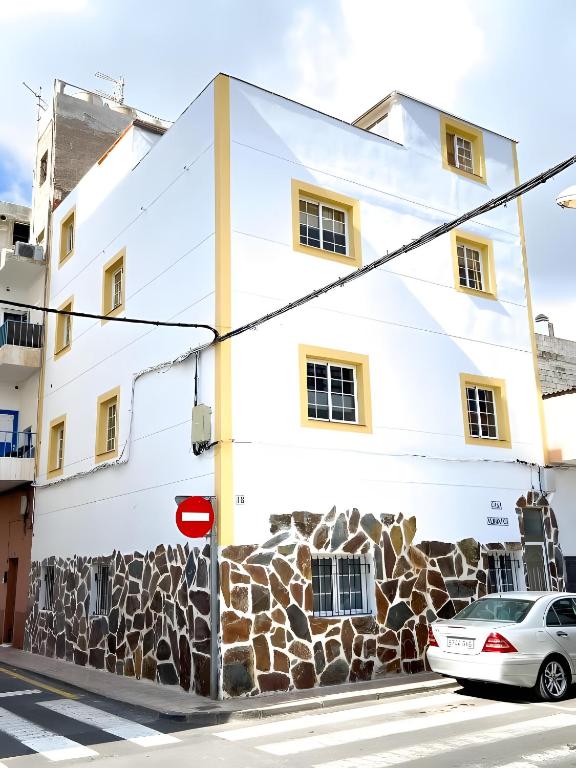 a white building with a car parked in front of it at Casa Veronica in Arona