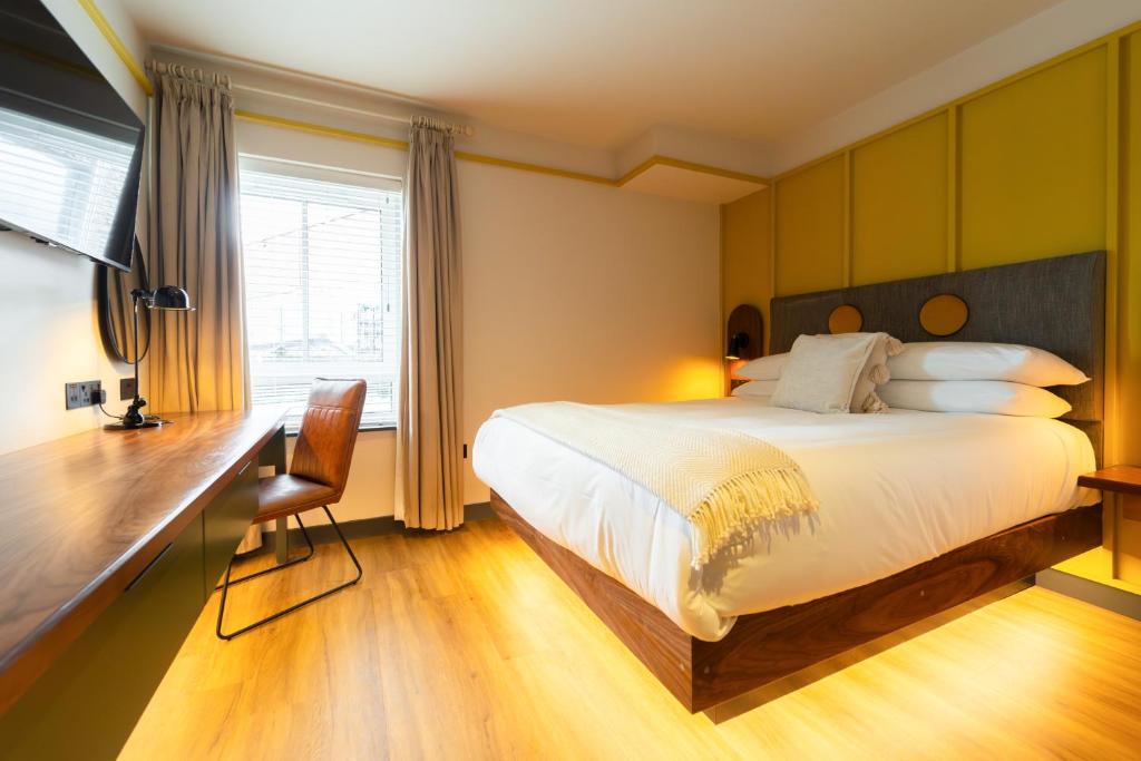 a bedroom with a large bed and a desk and a desk at Base Dingle in Dingle