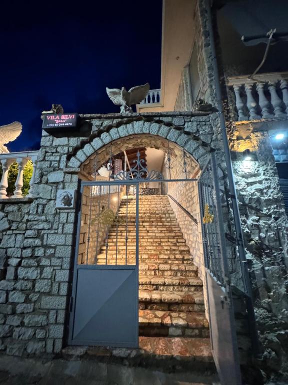 an entrance to a stone building with a gate and stairs at Vila Silvi Bala in Pilur