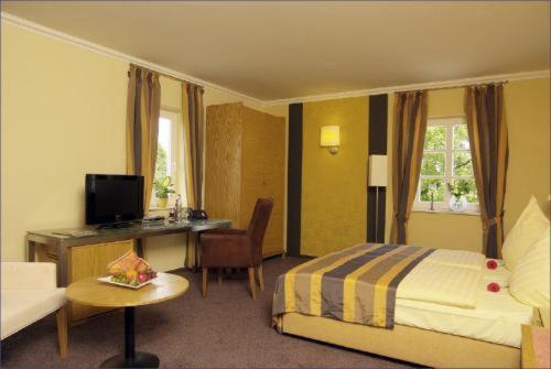 a hotel room with a bed and a desk at Hotel Sonnenhof in Perl