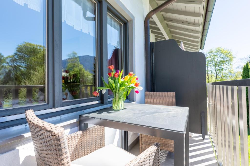 a vase of flowers sitting on a table on a porch at Gästehaus Wolfgang Taubensee in Ruhpolding