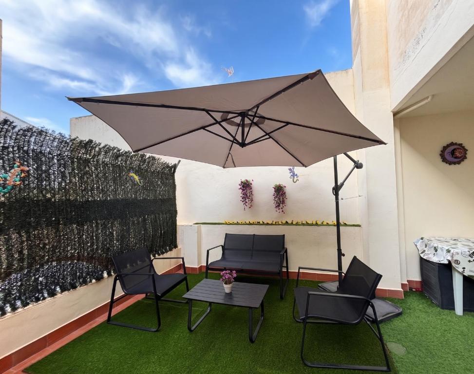 a patio with a table and chairs and an umbrella at El Patio de Chus by Clabao in San Javier