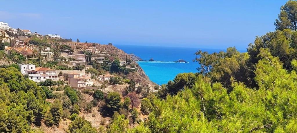a view of a hill with houses and the ocean at "The Chill Pad In Cotobro A Boutique Style Studio Where Chillin Is Easy" in Almuñécar
