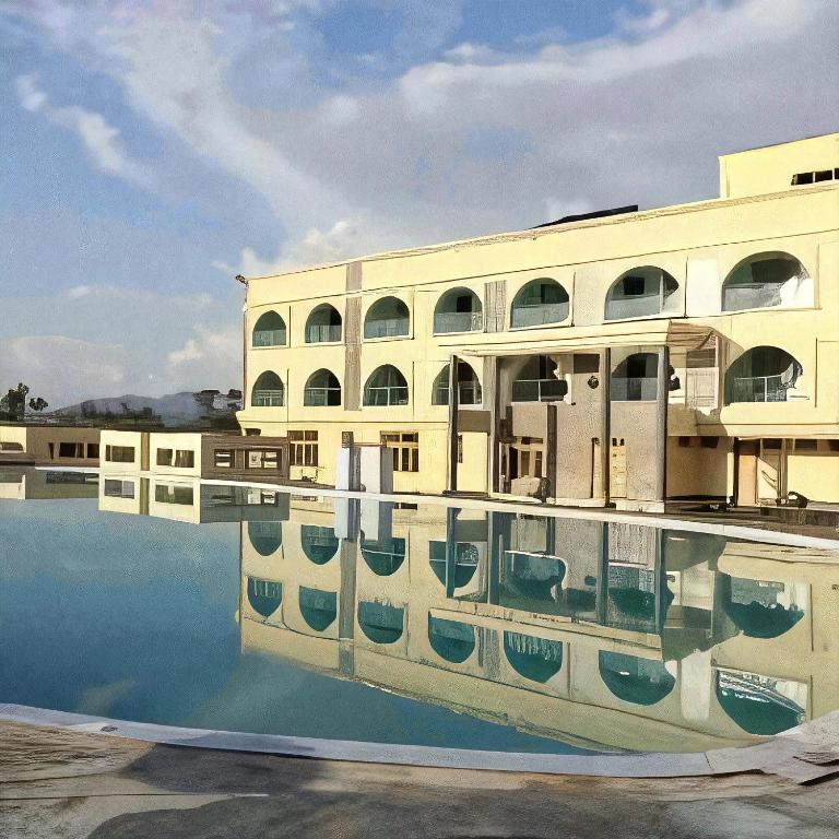 a building with its reflection in the water at The Africana Hotel in Isiolo