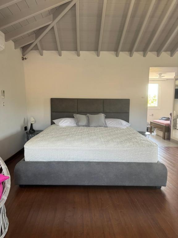 a bedroom with a large bed with a wooden floor at Romanou Guest House in Romanón