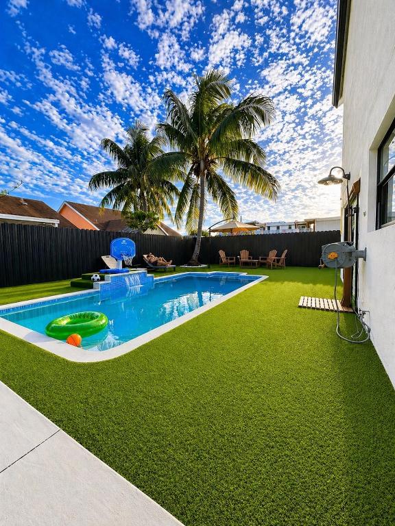 a backyard with a swimming pool and green grass at Casa Madrisqui Heated Pool Oasis 12 Guests Midway Keys & Miami in Homestead