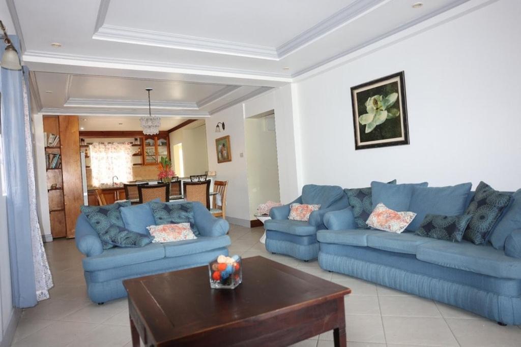 a living room with blue couches and a coffee table at Emerald Bleu Villa in Gros Islet