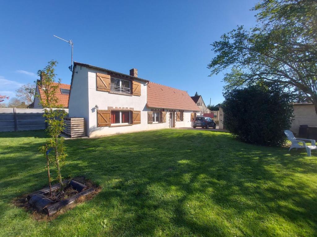 a small tree in a yard in front of a house at La Maison d'André in Digny