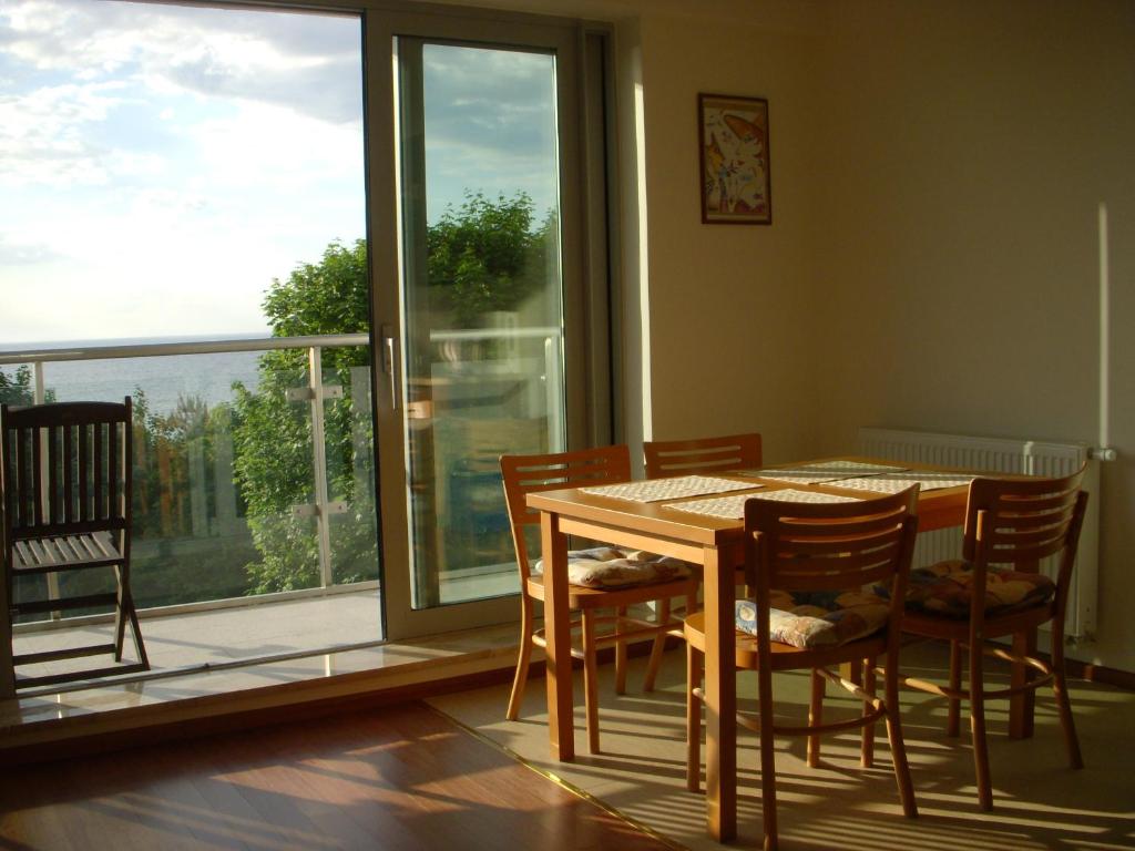 a dining room with a table and chairs and a window at Wechta with Sea View and Sauna Gratis in Międzyzdroje