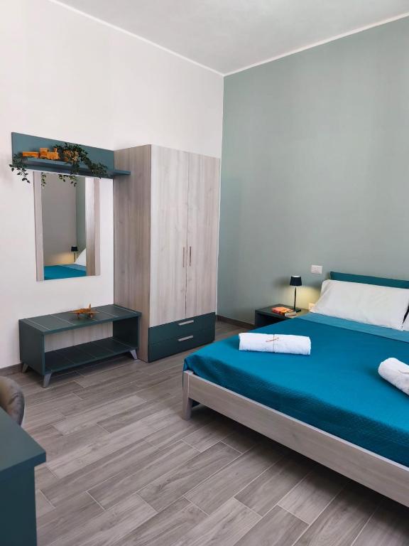 a bedroom with a blue bed and a mirror at B&B Casa Lina in Sarroch