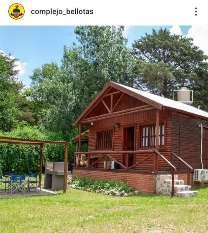 a log cabin with a porch and a patio at Complejo Bellotas in Agua de Oro