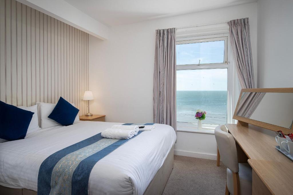 a bedroom with a bed and a window with the ocean at Hotel Santa Maria in Blackpool