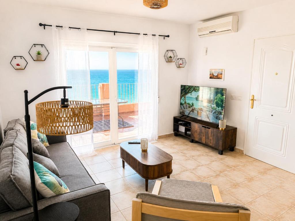 a living room with a couch and a tv at Mirador de las Gaviotas in Mojácar