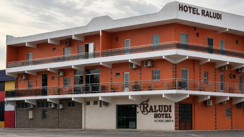 a hotel with a red building with a balcony at Raludi Hotel in Barcarena