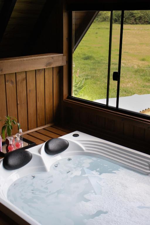 a bath tub in a room with a window at Recanto Deucher in Imaruí