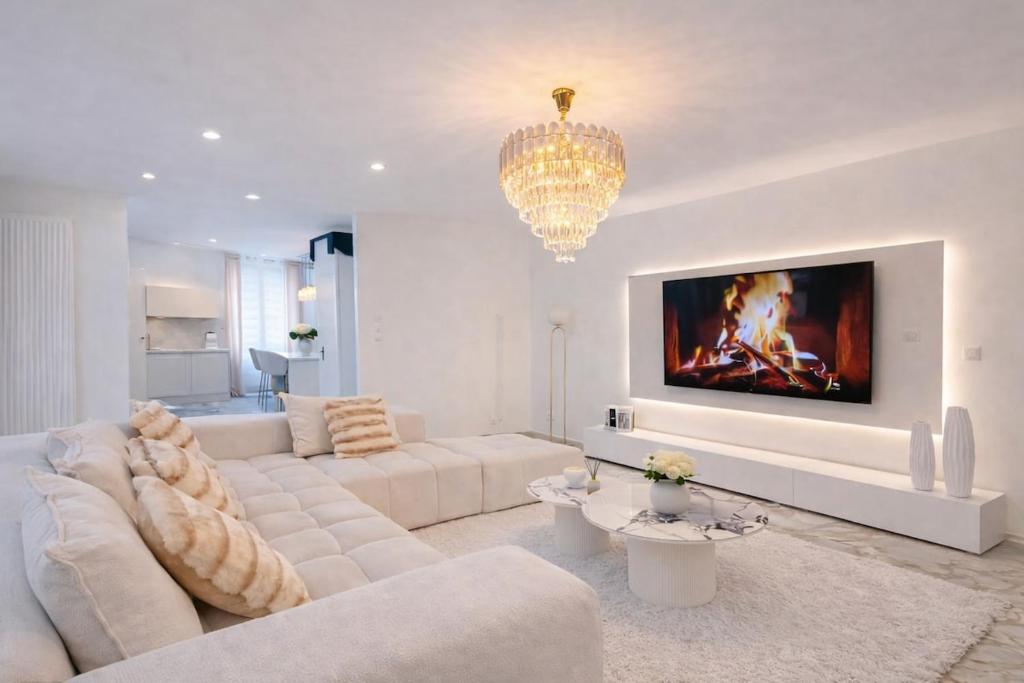 a living room with white furniture and a chandelier at Maison exceptionnelle - 6 pers - 3 chambres - Centre in Sablé-sur-Sarthe