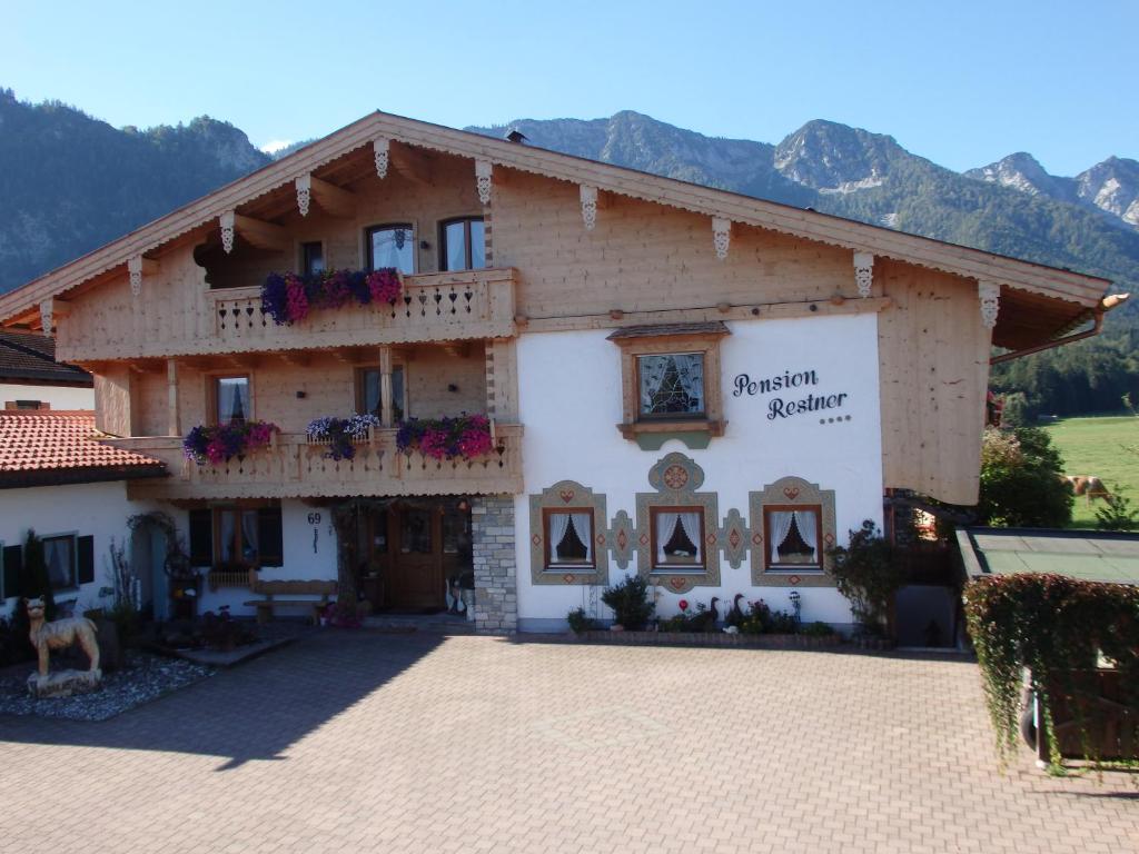 a building with flowers on the balconies of it at Pension Restner in Inzell