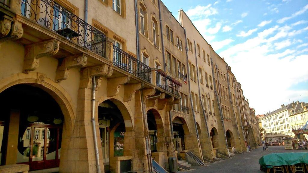 - un bâtiment avec des arches et des balcons dans une rue dans l'établissement Loft Le Saint Louis by La Chambre à Coté, à Metz