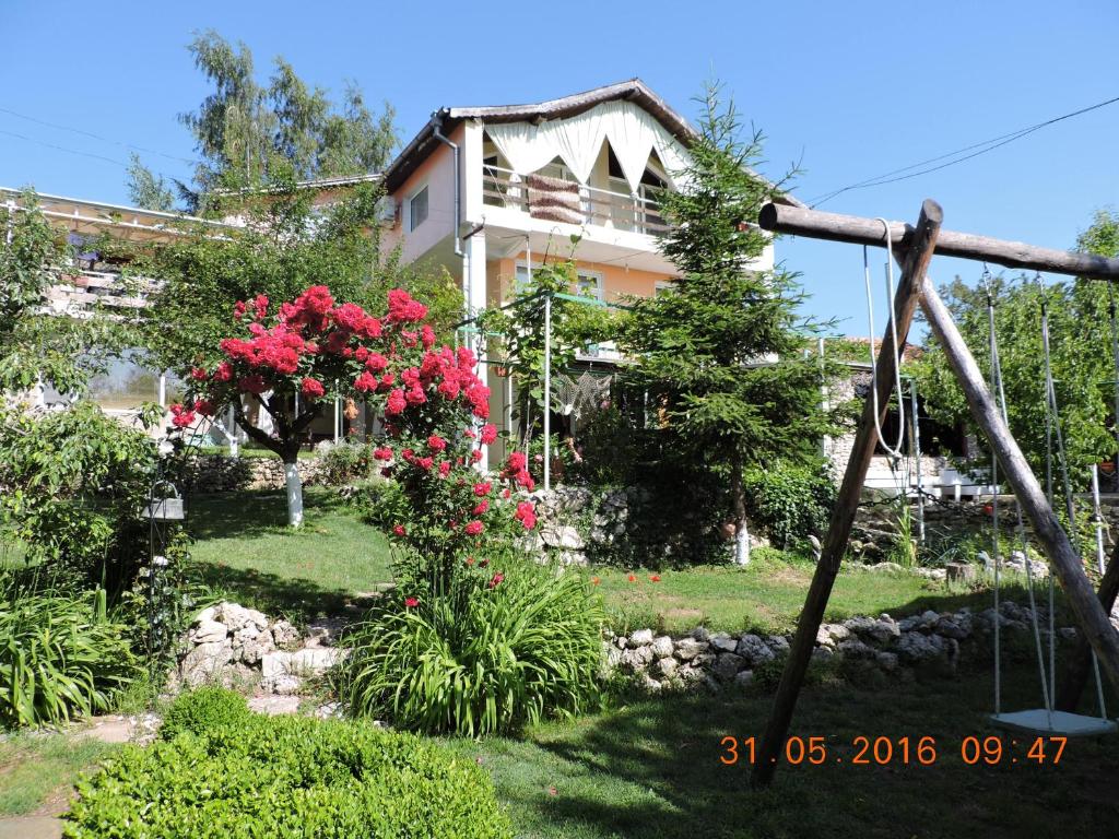 a house with a garden with flowers in front of it at Vila Chasovnikarov in Golden Sands