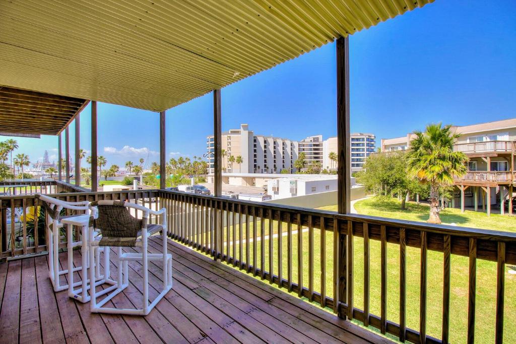 a balcony with two chairs and a view of a city at Bay Tree A3 in Port Aransas