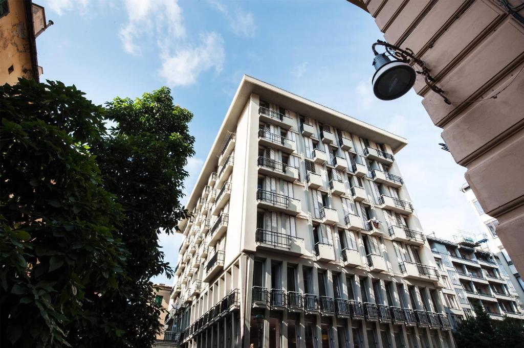 a tall white building with a lot of windows at Sure Hotel by Best Western Nologo in Genoa