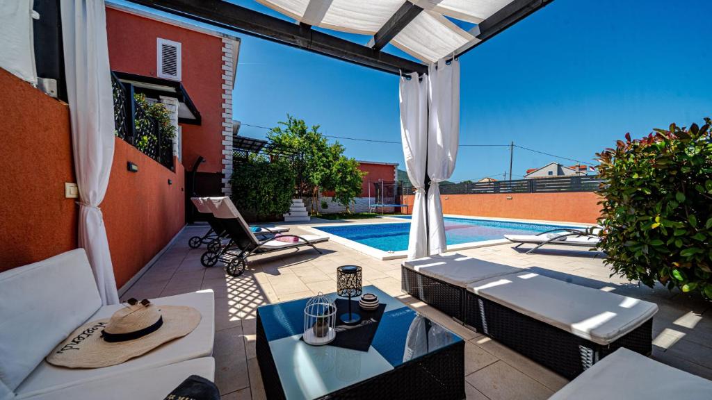 a patio with a table and a swimming pool at Villa Anna by Villas Guide in Vela Luka