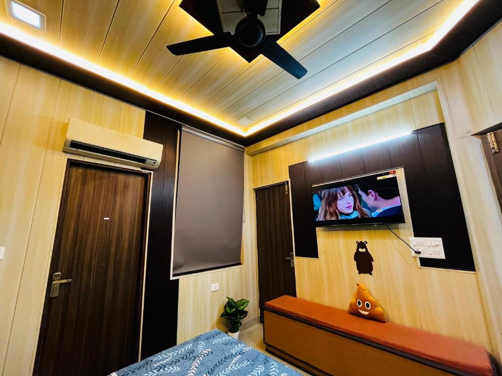 a bedroom with a ceiling fan and a tv on the wall at Oakèra in Agra