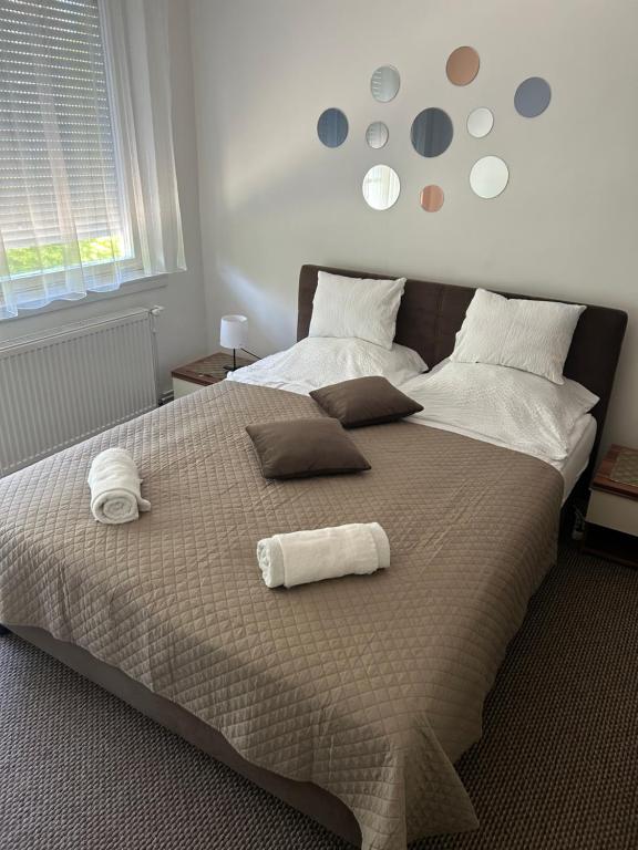a bedroom with a large bed with two rolled towels on it at Mokka Home in Békéscsaba