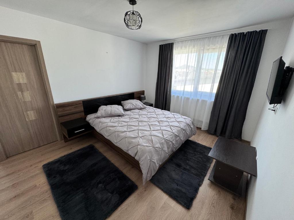 a bedroom with a bed and two rugs at Bounty Home in Bistriţa