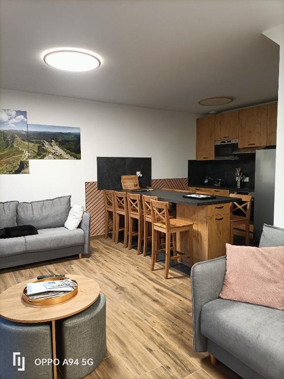 a living room with a couch and a table at Duplex T4 residence les Etoiles du Sud in Le Lioran