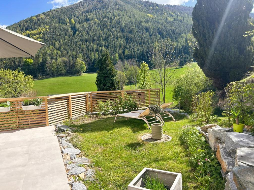 a garden with a bench in the grass at Feigenterrasse beim Semmering - Studio in Schlagl