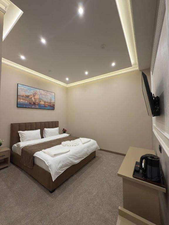 a bedroom with a bed and a tv in it at Almaz Hotel Uzbekistan in Tashkent