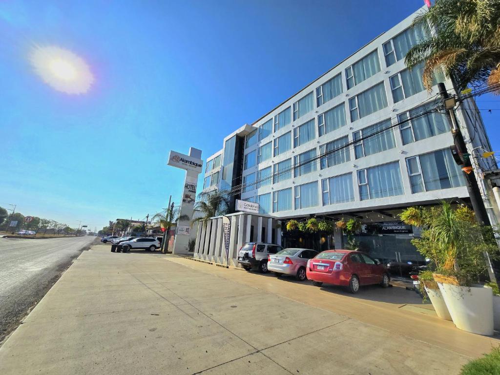 a large building with cars parked in front of it at Alambique Hotel Express in Arandas
