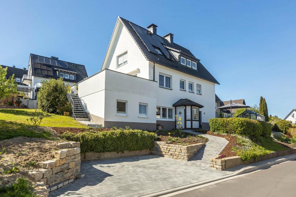 a white house with a black roof at Ferienwohnung Dicke Linde, 55qm in Schmallenberg