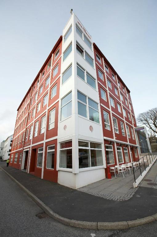 a large red and white building on a street at Hotel Tórshavn in Tórshavn