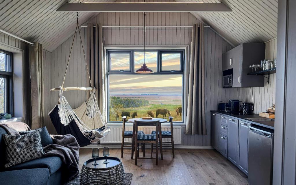 a room with a kitchen with a table and a window at Áskot Cottages in Hella