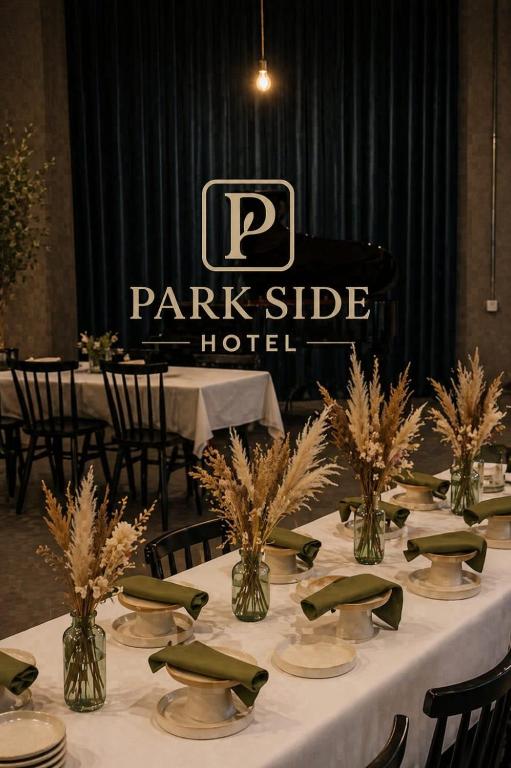 a table with plates and vases with plants on it at Park Side Hotel Tsalka in Tsalka