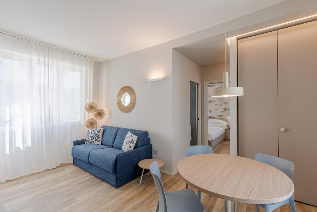 a living room with a blue couch and a table at Luxury Suites Collection - Ceccarini in Riccione