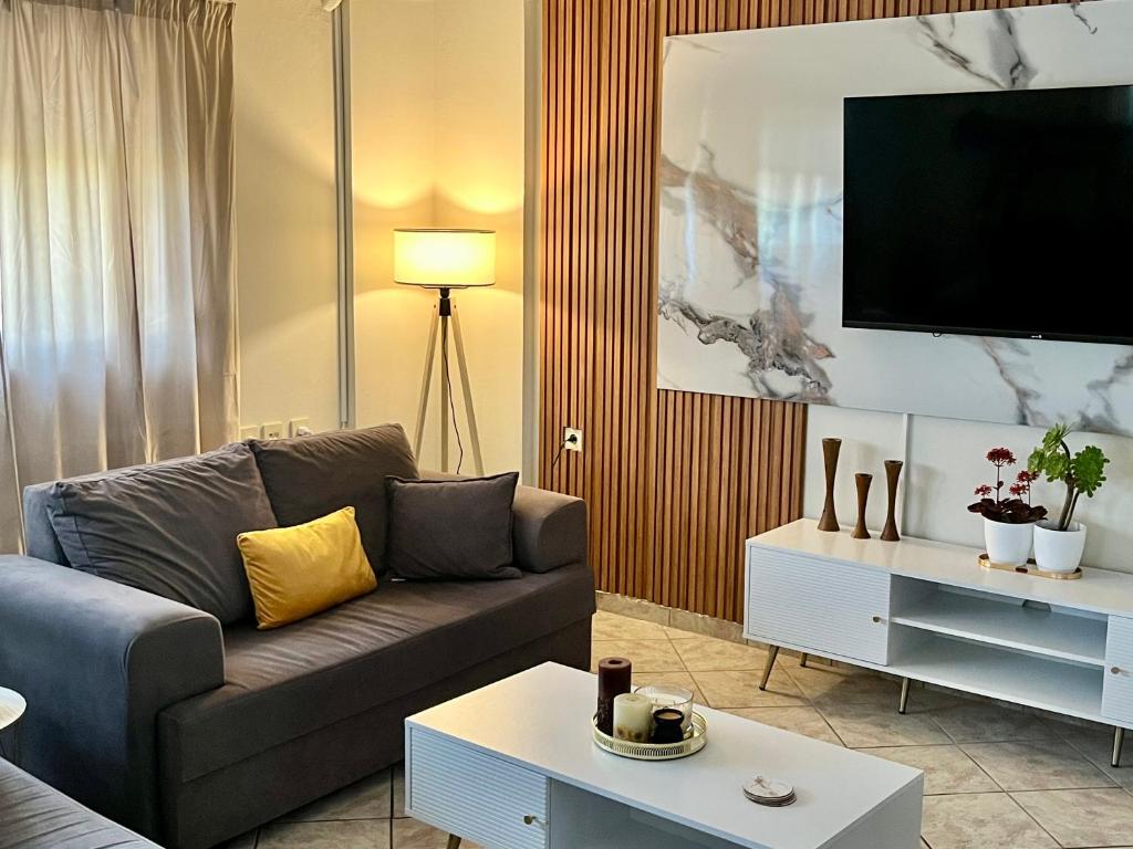 a living room with a couch and a tv at Windmill view apartment in Antimácheia