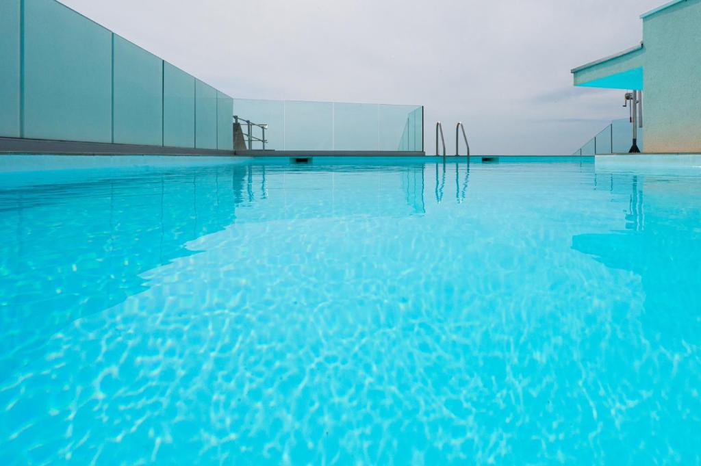 a swimming pool with blue water in front of a building at Nemea Appart Hotel Sunset Nice Arenas in Nice