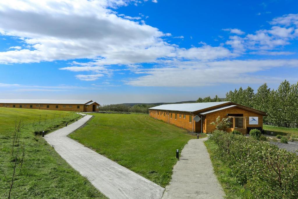 a building in a field next to a road at Hótel Eyjafjallajökull in Hvolsvöllur