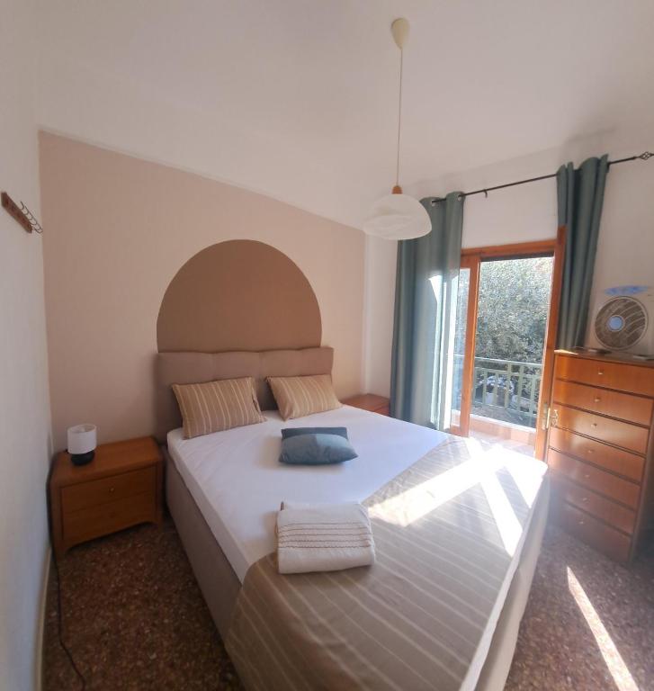a bedroom with a large bed and a window at Palm Memories in Ierissos