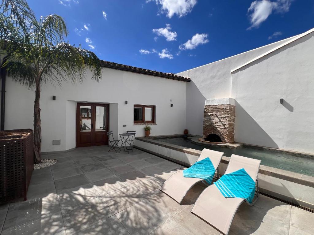 a patio with two chairs and a swimming pool at Casa Chula Estudio in Jimena de la Frontera