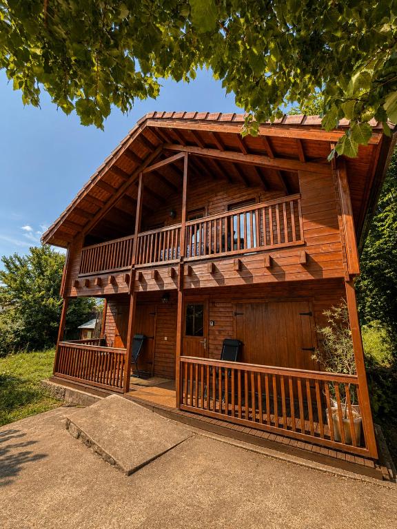 a large log cabin with a large deck at Casa rural 'La Huerta' in Rascafría