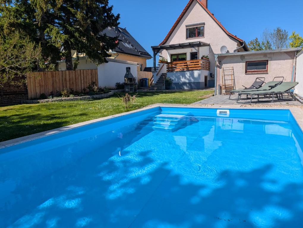 a swimming pool in the yard of a house at Ferienhaus Isabel in Gernrode - Harz